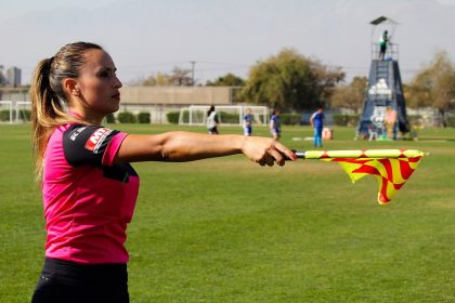 Ассистент арбитра поднимает флаг, фиксируя положение вне игры