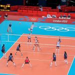 Либеро в форме другого цвета на приеме во время волейбольного матча