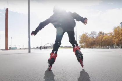 Райдер на роликах Rollerblade катится по городской набережной в солнечный день
