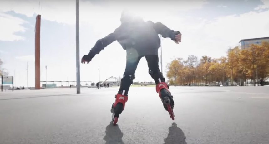 Райдер на роликах Rollerblade катится по городской набережной в солнечный день