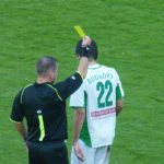 Арбитр показывает желтую карточку футболисту